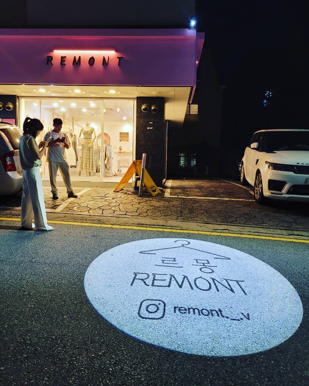 Custom REMONT logo projection on pavement by One Gobo, perfect for storefront marketing and outdoor events.